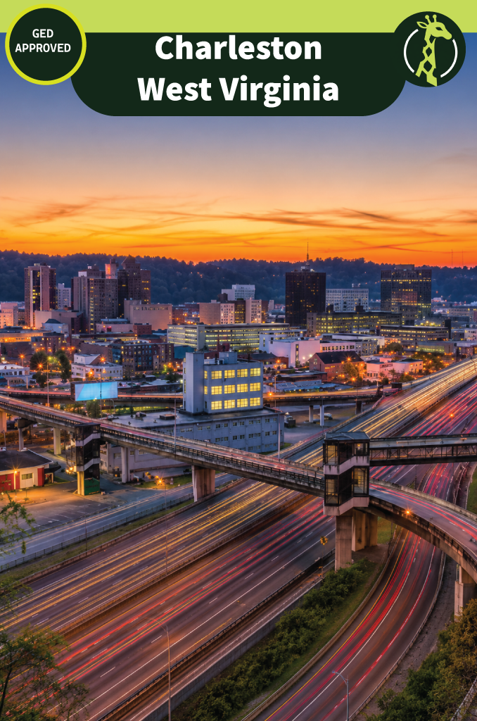 Downtown Charleston, West Virginia at sunset, with lit office towers above a wide freeway interchange carrying streaks of traffic light and wooded hills behind.